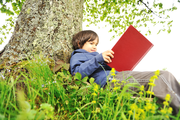 Happy Children Reading The Book Under The Tree Sbi 300996367 (1)