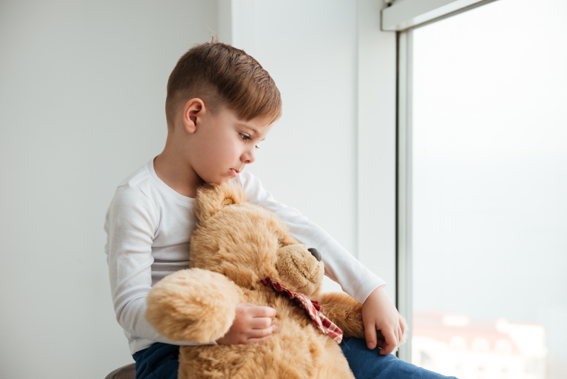 Picture Of Sad Boy Near Window With Teddy Bear Waiting For Parents At Home Look Aside SBI 303737280